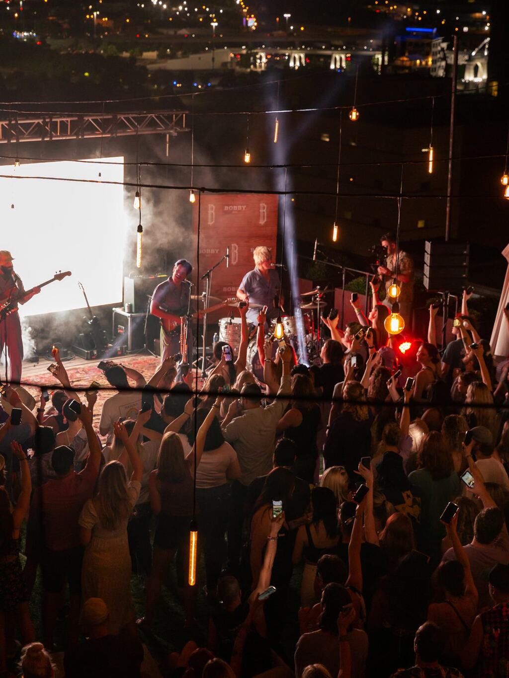 Image of a rooftop concert with a large crowd.